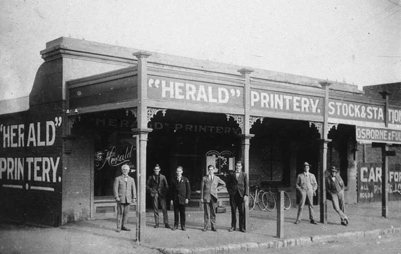 WH Pinkstone, on left, was the second Editor of the “Herald”, 1916-1950. Printery located in Wallendoon Street, Cootamundra. The Post Office was across the lane on the left, n.d. Image: NSW State Library collection. Reproduction: Peter de Waal